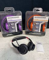 Two Jamsonic headphones in original packaging, purple and orange, with brand and product details visible.