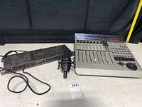 Full setup showing the Mackie MCU sound control surface, Rane equalizer with power cable, and microphone with shock mount on a table.