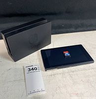 Nintendo Switch dock and console laid on table with Pokemon Brilliant Diamond game cartridge on console screen.