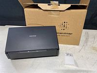 Scanner on table with original ScanSnap iX1600 box behind