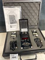 Overview of foam-lined carrying case showing handheld meter, two sensor probes with cables, and operator’s manual