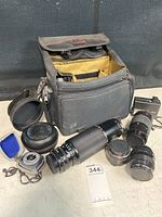 Open Vantage bag at center surrounded by lenses, flash and meter