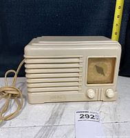 Front angled view of vintage FADA radio showing horizontal grille, dial and knobs with power cord.