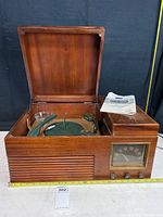 Wide front view of the open wooden cabinet showing the turntable and radio speaker grille