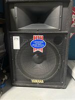 Front view of Yamaha S115lv speaker showing woofer, horn, and Yamaha logo.