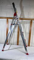 Full image of 3 ft aluminum folding platform ladder with red rubber feet and metal braces.