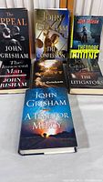 Front covers of six John Grisham hardcover books arranged together, showing titles and author's name.