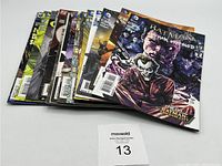 Seventeen Batman comic books fanned out showing many cover artworks including Batman, Joker and other characters.