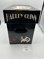 Black cardboard Harley Quinn comic storage box with logo on the side and character artwork on front and lid, shown closed.