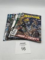 Photo showing the five Katana comics stacked slightly fanned with the front cover clearly visible on the top one