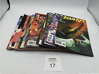 Stack of assorted comic books showing colorful vibrant covers, some with superhero and fantasy themes.
