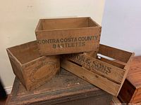 Photo showing three wooden crates including Contra Costa County Bartletts, L.L. Lyon & Sons, and another wooden crate.