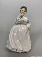 Front view of Royal Doulton Jessica figurine showing face, bonnet, capelet with green trim, and flowing white dress.