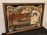 Overall angled view of the framed Coca-Cola advertising mirror showing the design and frame.
