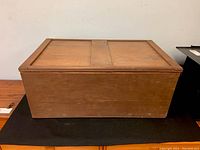 Front view of the rectangular handmade cedar chest showing surface wear and simple woodworking details.