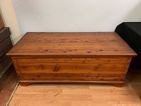 Front view of the cedar chest showing dovetail corner joinery and warm finish.