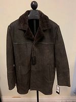 Full front view of brown suede shearling lamb coat on mannequin