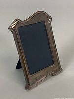Front view of vintage sterling silver photo frame with dark photo area and curved edges