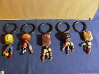 Set of five vintage napkin rings with colorful beads and wooden bands arranged in a row