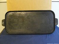 Top view of the rectangular cast iron griddle showing flat cooking surface and handles on both ends.