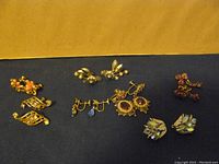 Nine pairs of vintage clip-on and screw-back earrings, various colors and designs on blue cloth background