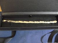 Full length image of sterling silver bracelet laid in a black jewelry box.