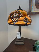 Front view of lamp showing illuminated mosaic shade and base