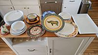 View of all plates, bowls, butter dish, and platters displayed on kitchen counter