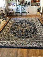 Full view of the large area rug showing its overall pattern and colors in a family room setting.