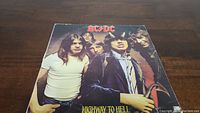 Front cover of AC/DC Highway to Hell vinyl record featuring the band members with Angus Young in costume.