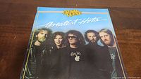 Front cover of April Wine Greatest Hits vinyl album showing band members in portrait and album title.