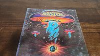 Front cover of Boston debut album vinyl record showing colorful spaceship artwork and band name.