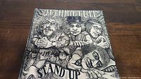 Front cover of the Jethro Tull Stand Up vinyl album showing illustrated caricatures of band members.