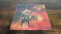 Front cover of Ozzy Osbourne vinyl album The Ultimate Sin showing artwork of woman and creature.