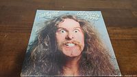 Front cover of the 'Cat Scratch Fever' vinyl album by Ted Nugent showing a close-up portrait of the artist with big hair and facial expression.