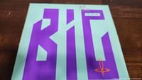 Front cover of BIG Generator vinyl album with purple background and large stylized letters