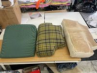 Three assorted pillows placed side-by-side on a table showing different shapes and fabric types