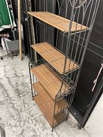 Full view of the wicker shelf with five tiers, showing the shelving unit standing upright.