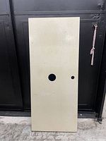 Full view of the beige countertop showing two circular holes against a black background.