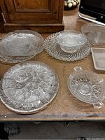 Top view of various vintage clear glass dishes showing detailed patterns and textures.