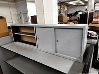 Close-up angled front view showing partial interior shelving and sliding doors, illustrating the need for proper door installation and condition of the surface.