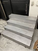 Front view of the silver 4-step wooden stair display showing the paint wear and overall shape.