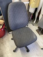 Overall view of gray fabric swivel office chair showing seat and backrest with no armrests.