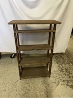 Full front view of vintage wooden shelving unit showing all four shelves and weathered wood condition.
