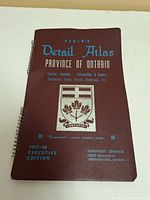 Front cover of the 1957-58 Perly's Detail Atlas for Province of Ontario, featuring map info and coat of arms.