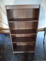 Front view of four-shelf wooden bookcase showing entire structure.