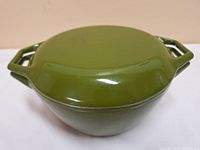 Top view of closed green enamel cast iron casserole with lid showing glossy finish and angular handles.