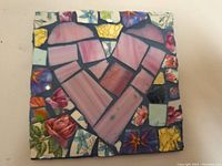 Close-up photo of the 6x6 inch mosaic heart artwork showing pink and purple crockery pieces forming a heart shape surrounded by multicolored broken patterned crockery pieces.