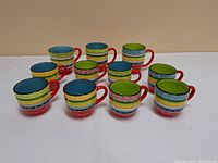 Full set of 10 colorful striped ceramic mugs arranged in 2 rows