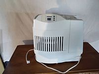 White Noma humidifier with vents on front and top, power cord visible.